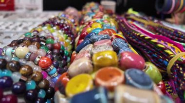 Parlak renkli boncuklar ve mücevherler müşteriler için sergileniyor.