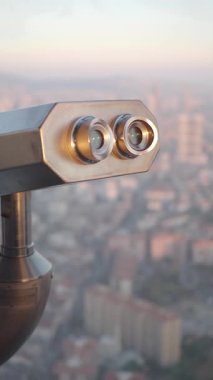 Şehrin ufuk çizgisine bakan teleskopa yakından bakın..