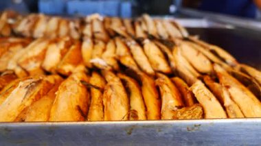 Taze hazırlanmış ızgara balık kalabalık bir pazarda sergileniyor..