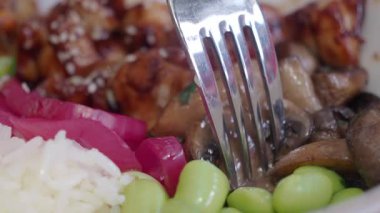 Tavuklar, mantarlar ve pirinçten oluşan renkli bir yemeğin yakın çekimi..