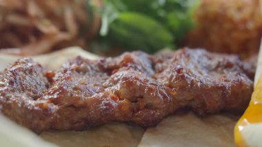 Taze yeşillik ve yanlarla servis edilen taze ızgara etin yakın çekim görüntüsü.