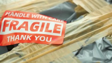 İşçiler yoğun bir nakliye merkezinde kırılgan eşyaları dikkatle yönetirler..