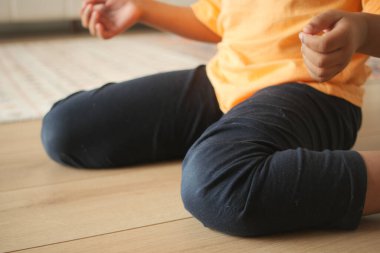 Tahta bir zeminde otururken bir çocuk .