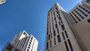 Yeni mimari yapılar parlak mavi gökyüzünün altında yukarıya doğru uzanır..