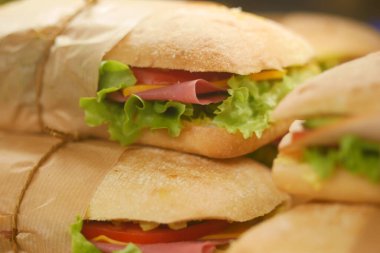 Sandwiches filled with lettuce, tomato, and meats await customers in the deli.