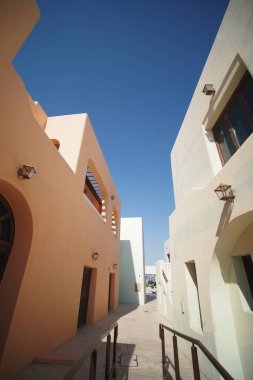 Parlak boyanmış binalar güneşli bir günde dar bir yürüyüş alanı oluşturuyor..