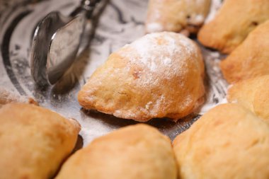 Freshly baked pastries scattered on a silver platter, ready to be served.