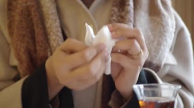 Kadın elini temizlemek için mendil kullanıyor. 