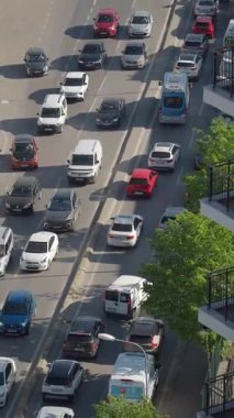 Arabalar araçlarla dolu işlek bir şehir yolunda yavaşça ilerliyorlar..