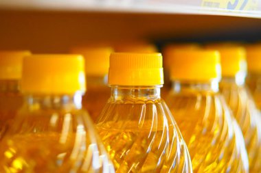 Sıralar dolusu şeffaf yağ şişeleri ve sarı başlıklar..