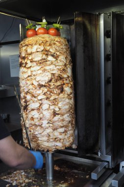 Meşgul bir mutfakta düşey bir rostoda leziz shawarma pişirme.