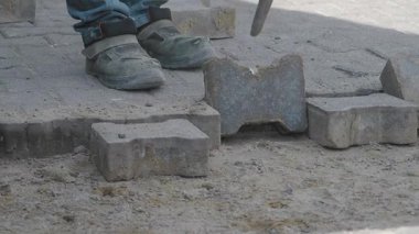 İşçiler yeni bir yol için taşları dikkatlice yere yerleştirirler..