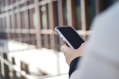 Modern yapının yanında akıllı telefonu olan, açık havayı seven biri..