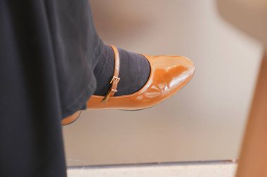 Gri çoraplı turuncu bir ayakkabının yakın çekimi..