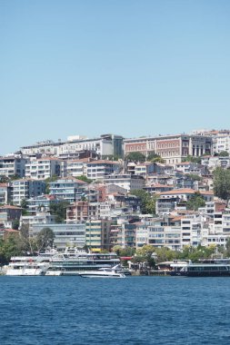 Gökyüzü açık bir günde İstanbul 'un kıyı şeridi boyunca çeşitli binaları gösteriyor.