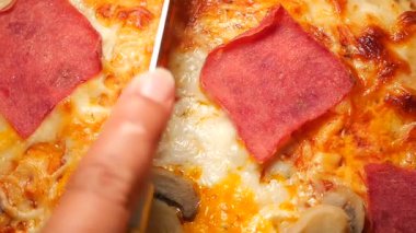 Lezzetli bir pizzanın dilimlenişini izleyin. İçindeki peyniri ortaya çıkarıyor..