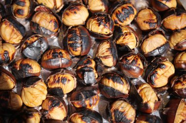 Kavrulmuş kestaneler düzgün bir düzende oturur, altın renklerini sergilerler..