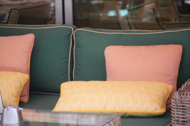 Yumuşak yastıklar rahat bir açık hava oturma alanını dekore ederek rahatlamaya yardımcı olur..