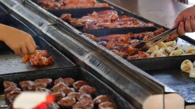 Şefler açık havada canlı bir toplantıda tavuk ve biftek pişiriyor..