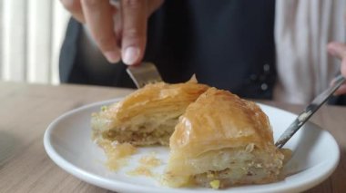 Sıcak bir atmosferle servis edilen bir tabakta taze yapılmış baklavanın tadını çıkarıyorum..