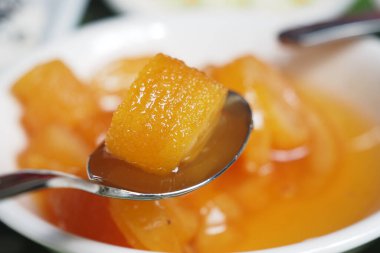 Bir kaşık, bir küp tatlı tropikal tatlıyı kaseden kaldırır..