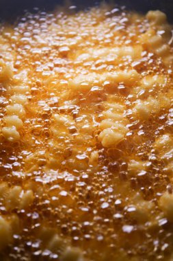 Taze kızarmış hamur parçaları kızgın yağda cızırdar, çıtır çıtır bir doku yaratır..