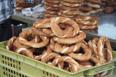 Hareketli bir pazarda güneşli bir günde yığınla simit sergilenir.