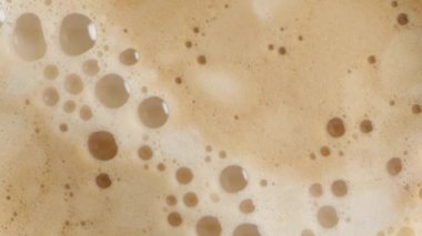 Taze demlenmiş kahvenin üzerindeki köpüklü, zengin köpüklü formları izleyin..