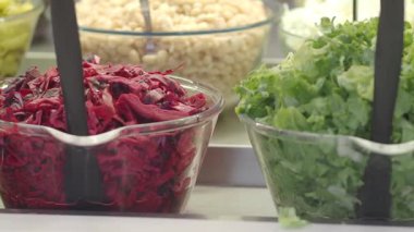 Kırmızı lahana ve marul dahil taze sebzeler bir salata barında sergilenir..