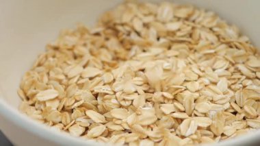 Yulafların yavaş çekimde kabın içine dökülmesi ,