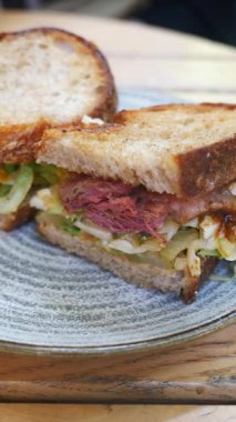 Taze sandviç lezzetli et katmanları ve gevrek sebzeler içerir..