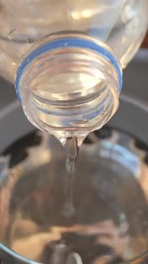 Temiz sıvı şişeden kaseye dökülüyor..