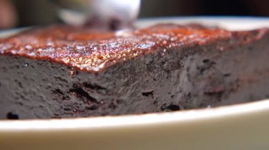 Sıcak bir kafe ortamında zengin çikolatalı kekin tadını çıkarıyorum..