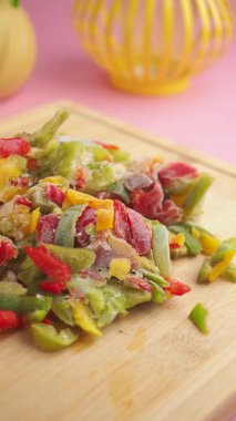 Doğranmış donmuş sebzeler kesim tahtasında, hızlı yemek için idealdir..