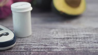 Tahta bir masada glikoz ölçer ve taze sebzeler sergilenir..