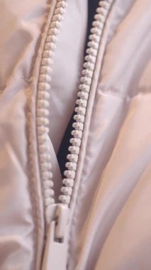 Kabarık ceketin fermuarına yakından bak..