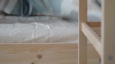 Sakin bir odada yumuşak battaniyeler düzgün bir şekilde yerleştirilmiş bir yatağın üzerine serilir..