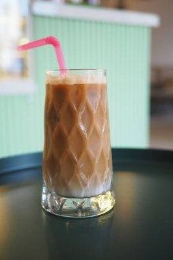 Buzlu kahve, pembe pipetle desenli bir bardakta servis edilir..