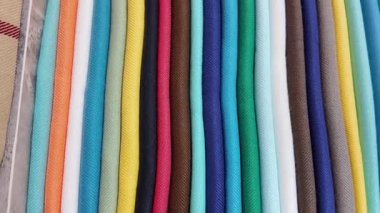 Parlak renkli kumaş ruloları bir mağaza ortamında sergileniyor..