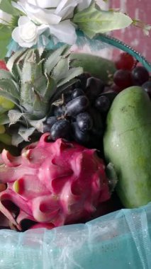 Taze tropikal meyvelerden oluşan canlı bir karışım sepetin içinde güzelce sergilenir..