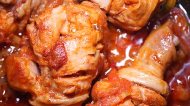 Taze tavuğun zengin, baharatlı domates sosunda pişişini izleyin..