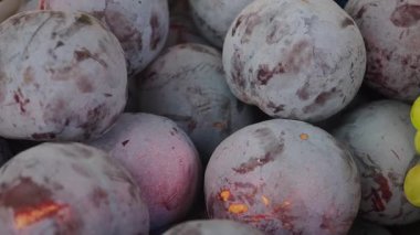 Renkli, olgun erikler hareketli bir pazarda sergilenir..