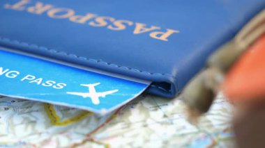 Bir seyahat haritasında pasaport ve biniş kartı yakın plan.