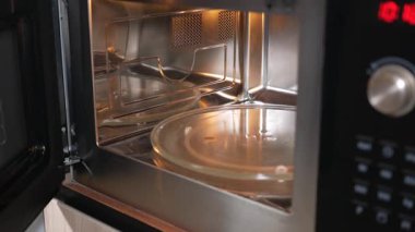 Ayrıntıları temiz tasarım özelliklerine sahip bir mikrodalga fırının içinde göster.