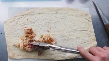 Bir şef lezzetli bir yemek için hamura ustaca baharatlı tavuk ekler..