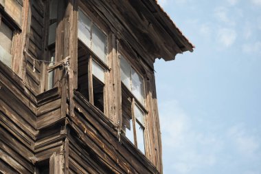 Yıpranmış ahşap yapı mavi gökyüzünün altındaki kırık camları gösteriyor.