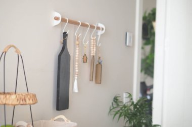 Dekor malzemeleriyle ahşap kancalar sergilenen şık bir mutfak duvarı..