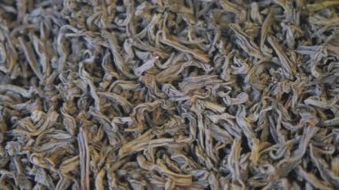 İnsanlar çeşitli yaprak çay seçenekleriyle dolu bir pazarı keşfediyorlar..