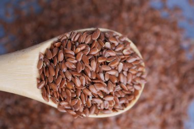 Ahşap bir kaşıkta keten tohumlarının yakın çekimlerinde dokuları sergilenir..