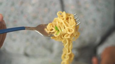 Erişteler bir çatalın etrafında kıvrılır ve öğle yemeği için hazır olur..